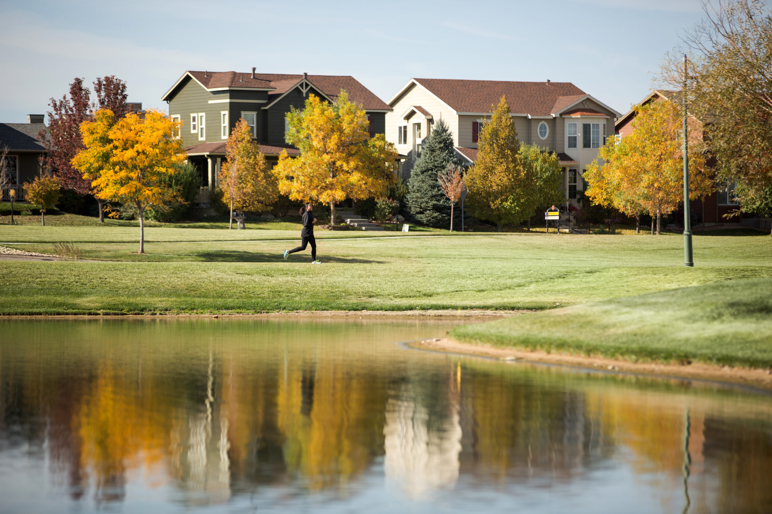 person jogging by pond during fall at Reunion