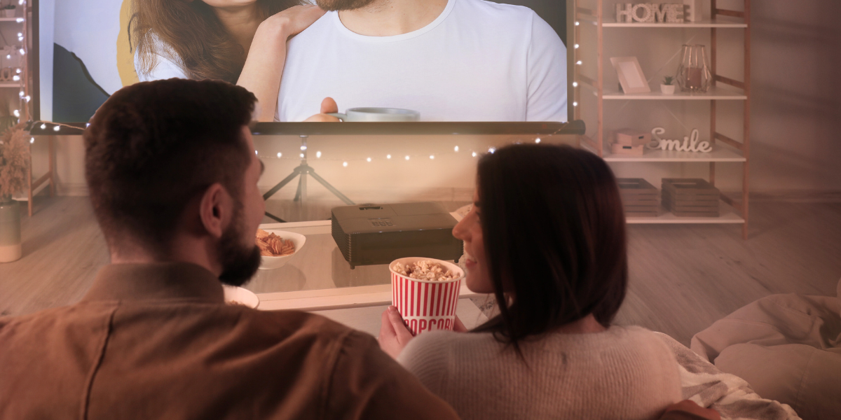 Couple enjoying a movie night in their living room with popcorn.