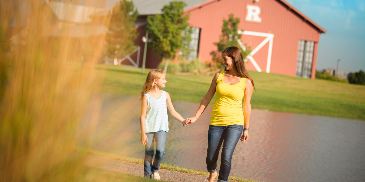 Woman and child walk in a fall park at Reunion. 