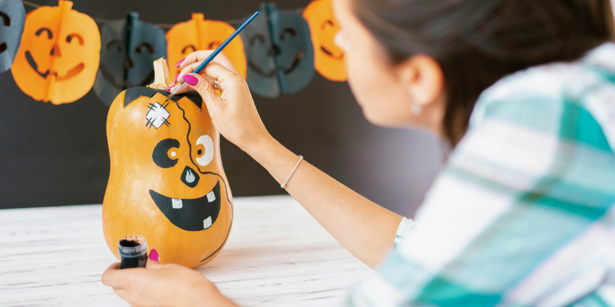 Person painting a pumpkin. 