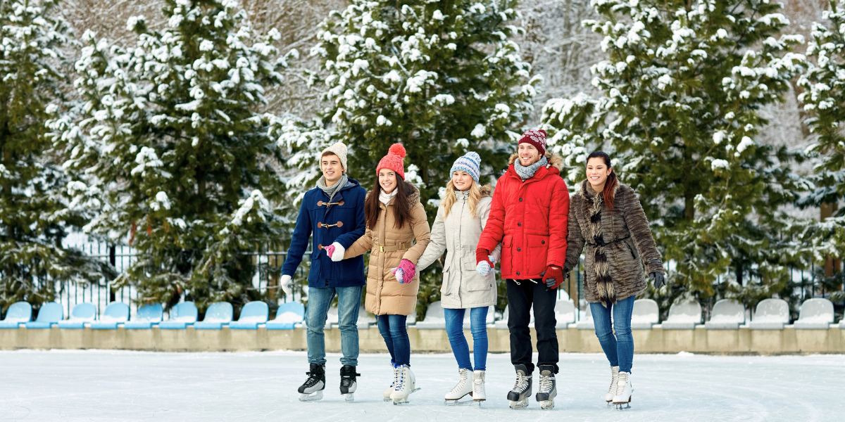 People ice skating on a holiday ice skating rink.
